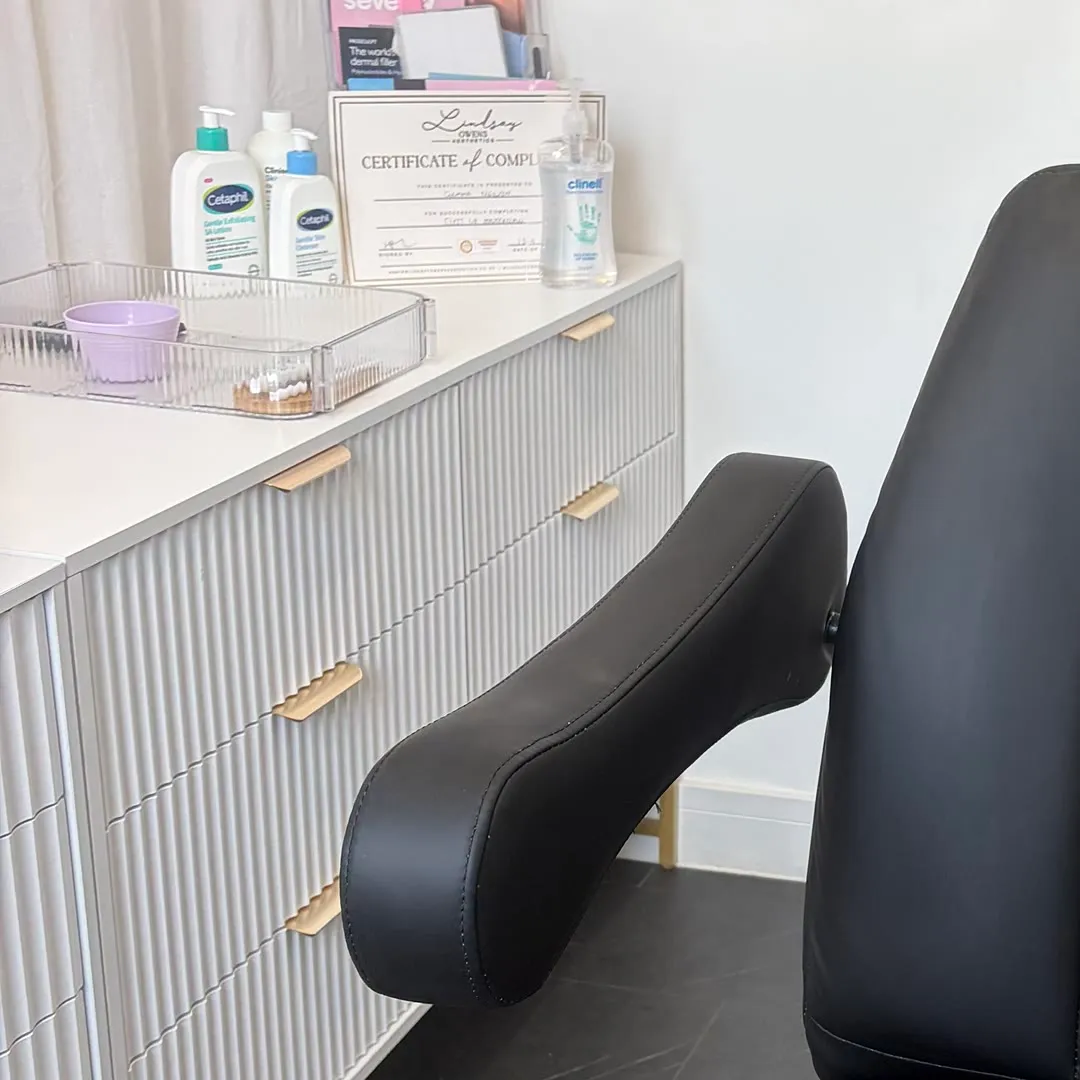 Skincare products and a certificate on the treatment room dresser